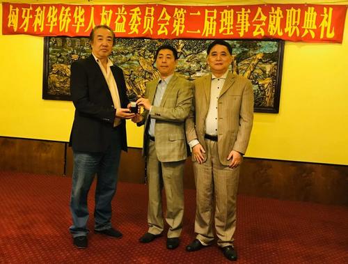 中国侨网匈牙利华侨华人权益委员会首届主席张国治(左)向第二届新主席刘志辉(中)交接印信,名誉主席刘文建(右)见证。(匈牙利《欧洲论坛报》)