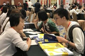中国侨网一名学生在细心咨询留学事宜。(图：香港文汇网/卢静怡 摄)