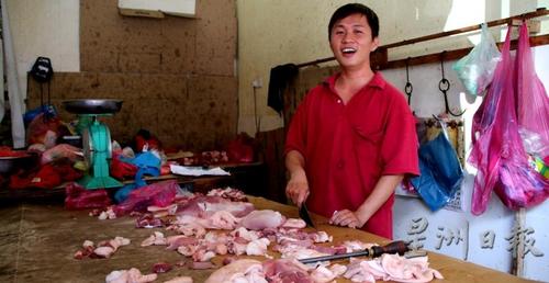 中国侨网图为谢坚杰在卖猪肉。（马来西亚《星洲日报》）