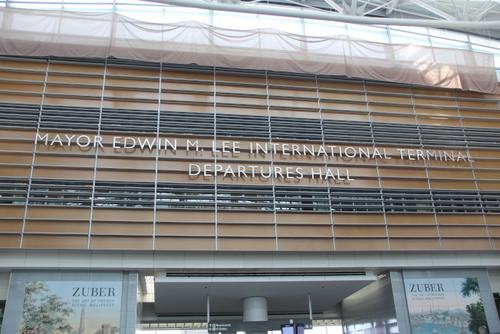 中国侨网旧金山国际机场“李孟贤市长国际航站楼出境大厅”字样位于厅内的中间上方，正对入口。(美国《世界日报》/李晗 摄)