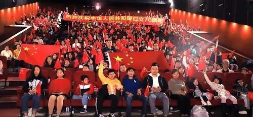 中国侨网观众高举国旗在电影放映厅合影。(《欧洲时报》/林碧燕 摄)