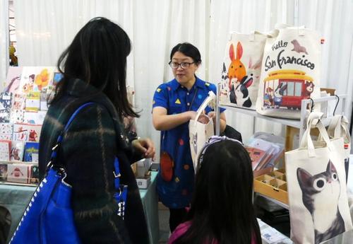 中国侨网图为张子欣为顾客介绍她设计的手包。(美国《世界日报》／梁雨辰 摄)