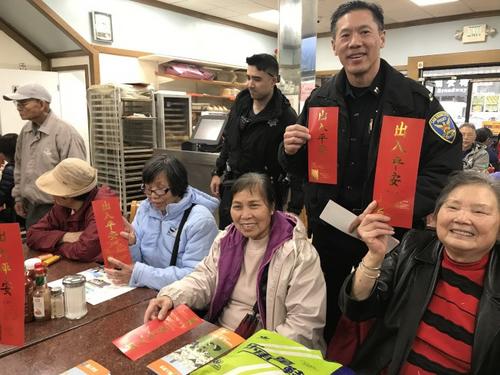 中国侨网中央分局易文耀在华埠展开农历新年防罪宣传,包括派发挥春。(美国《世界日报》/李秀兰 摄)
