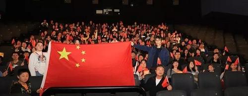 中国侨网观影前,观众高举国旗在电影放映厅合影。(《欧洲时报》/林碧燕 摄)