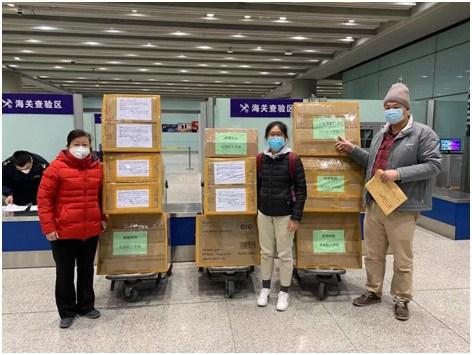 中国侨网张锦雄捐赠的1万个口罩送达首都机场，左起：北京市红十字会李老师，热心帮忙的王同学，北京博越清关代理公司陈总。严君供图