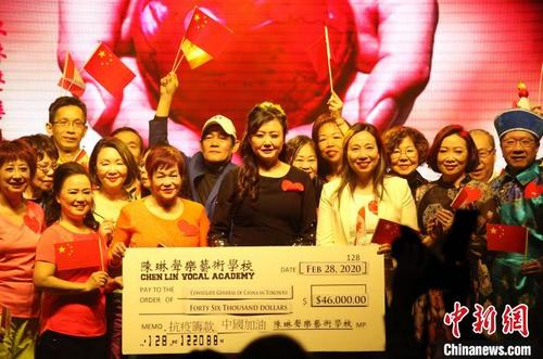 中国侨网图为陈琳（中）与她的声乐艺术学校学员及出席演唱会的嘉宾等共同展示捐款金额。　余瑞冬　摄
