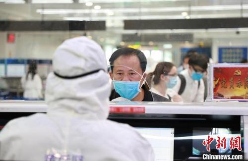 中国侨网图为在南昌昌北国际机场口岸通关现场,边检民警详细询问每一名旅客的境外活动情况和健康状况。 李云瑞 摄