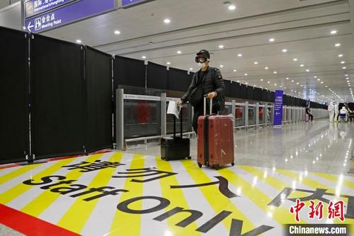 中国侨网入境人员推着行李在浦东机场T2航站楼到达层行走。　殷立勤　摄