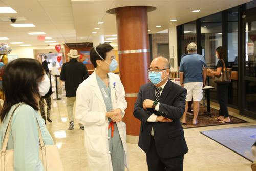 中国侨网靳敏医师（中）向李雄（右）等说明医院收治新冠肺炎患者的过程。（美国《世界日报》/封昌明 摄）