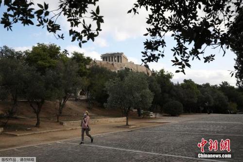 中国侨网资料图：希腊雅典，一名戴口罩女子经过帕特农神庙。
