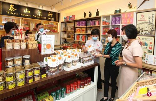 中国侨网新加坡国家发展部兼通讯及新闻部高级政务部长沈颖(右一)和贸工部兼文化、社区及青年部政务部长刘燕玲(右二)到访牛车水的泰山药行,向总经理陈美仪(右三)了解商家对数码化转型计划的看法。(新加坡《联合早报》/周国威 摄)