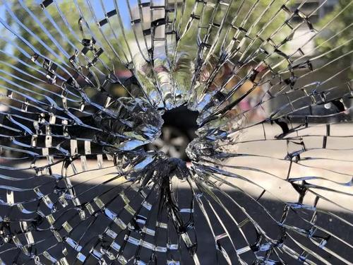 中国侨网子弹打中华人理发店的玻璃门窗。（美国《世界日报》/刘先进 摄）