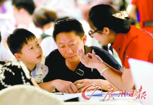 中国侨网不少家长带着孩子前来选择暑期旅游产品。(广州日报/庄小龙 摄)