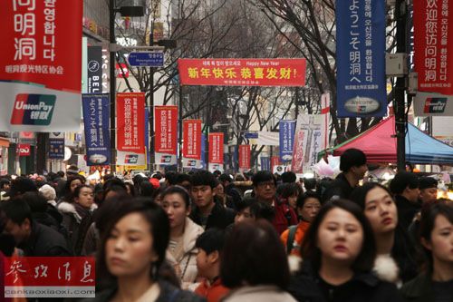 资料图:在韩国首尔,明洞购物区的街道上挂出“欢迎您访问明洞”和“新年快乐,恭喜发财”等字样的条幅。(参考消息援引新华社/姜惺彬