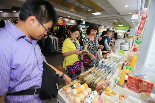 正在免税店选购化妆品的中国游客(韩联社)