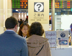 图为11月25日站员在JR东京站丸之内地下中央口的问询处向外国游客进行解答。（日本共同社）