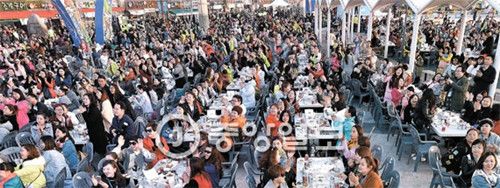 图为正以七天六夜日程访韩的中国傲澜集团4500名员工3月28日正在仁川月尾岛文化街举行“啤酒炸鸡派对”。他们吃了3000只炸鸡、750份炸薯条，喝了4500听罐装啤酒。