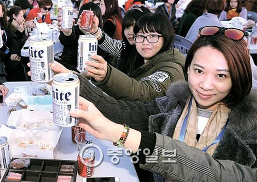 饮用听装啤酒的中国游客