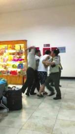 越南边检人员将一名中国男游客抓住，一名边检人员还有肘击其背部的动作。图片据网友