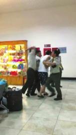 越南边检人员将一名中国男游客抓住,一名边检人员还有肘击其背部的动作。图片据网友