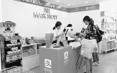 首尔明洞商圈一家化妆品店内,中国游客正在可以使用支付宝付款的柜台结账。陈尚文摄
