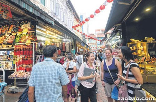 热闹的登嘉楼街曾经有数百家妓院林立，导游陈丽珠（右三）向参加夜间游的游客讲述当年妓院和妓女的故事。（新加坡《联合早报》/林国明