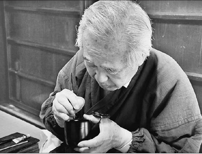 “莳绘师”平野雄一已经从业近50年了,他笔下的图案包含着对四季变化和人生的感悟。图为平野正在半成品的漆器上绘图。