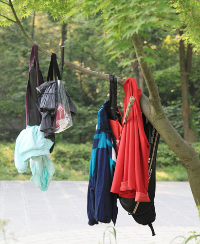资料图片：游客把衣服、袋子等物品悬挂在南京中山风景区一棵小树上。