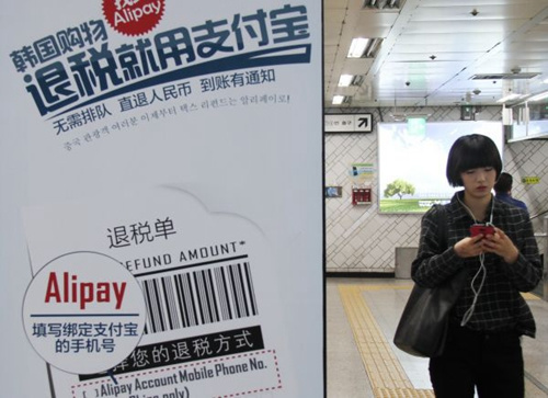 支付宝早已走出国门,这是2014年11月5日,一名行人走过首尔地铁里的支付宝广告。新华社记者姚琪琳摄