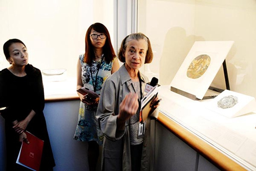 博物馆的工作人员向记者介绍新增添的中国文物珍品-元明时期的“月中仙子”的嫦娥扇面。（张大卫摄）