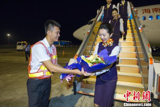 图为海口-河内航线首航机组人员接受赠花。 骆云飞 摄