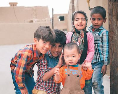 中国侨网在伊朗亚兹德老城，当地小孩和贩暖的儿子开心玩耍。贩 暖摄