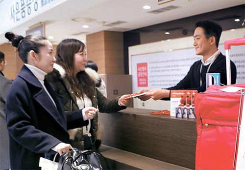 中国侨网图为中国游客正在位于首尔小公洞的乐天百货总店领取赠品。（乐天百货供图）