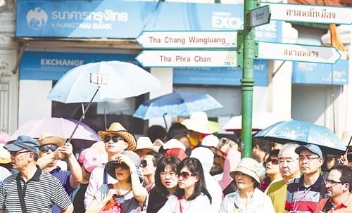 中国侨网中国已是目前泰国旅游业最大的市场，且还在不断增长。图为在泰国曼谷，游客在大皇宫附近的一个路口等候。（经济日报）