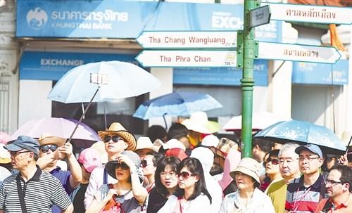 中国侨网中国已是目前泰国旅游业最大的市场,且还在不断增长。图为在泰国曼谷,游客在大皇宫附近的一个路口等候。(经济日报)