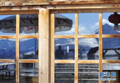 中国侨网1月26日，在瑞士一家滑雪场，山腰一家餐厅的窗户上映出雪山。新华社记者叶平凡摄