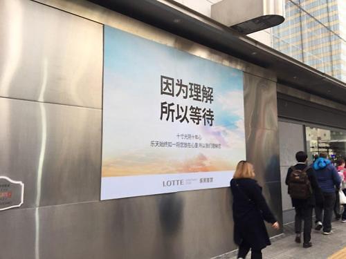 中国侨网在明洞乐天百货本店外张贴有“因为理解，所以等待”的海报