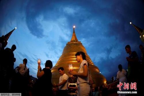 中国侨网当地时间2017年5月10日，泰国各地民众庆祝卫塞节，民众手举蜡烛祈祷。