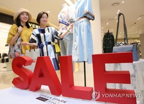 中国侨网资料图片:6月14日,在位于首尔龙山区的新罗爱宝客免税店,顾客挑选衣服。(韩联社)