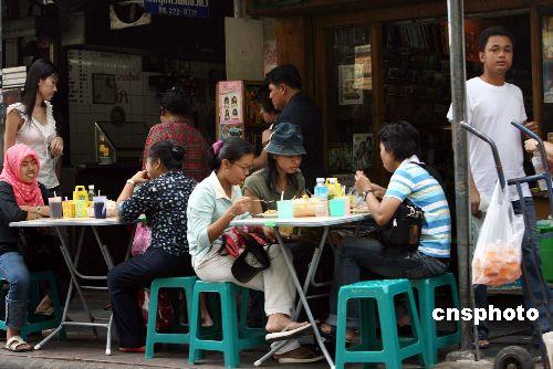 中国侨网资料图：在曼谷市区街道两旁的地道小吃吸引不少游客品尝。