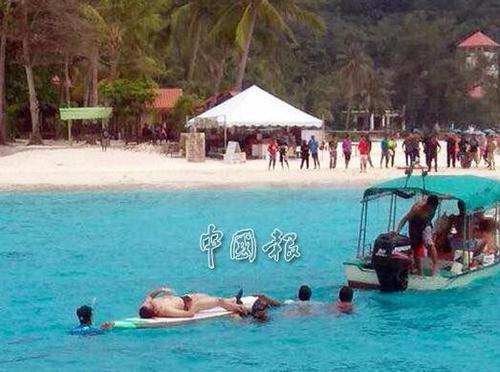 中国侨网图为搜救队伍将死者遗体载上岸。（马来西亚《中国报》）