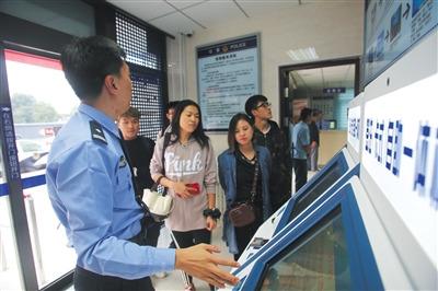 中国侨网通州公安分局出入境自助服务厅，民警介绍自助签注机的功能和使用方法。