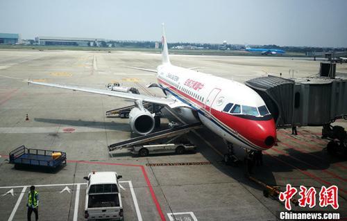 中国侨网资料图：停机坪上正在上客的客机。 中新社记者 刘忠俊 摄