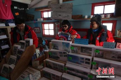 中国侨网中国国内一家旅行机构所带领的游客在南极探险旅行,勒克罗伊港英国科考站购物。(中新网记者 刘延珉 摄)