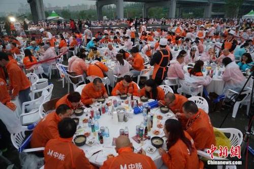 中国侨网资料图:中国4000名团体游客在韩国首尔汉江公园露天广场品尝韩国传统美食参鸡汤,并欣赏热播韩剧《太阳的后裔》迷你音乐会。图为参鸡汤派对现场。 中新社记者 吴旭 摄