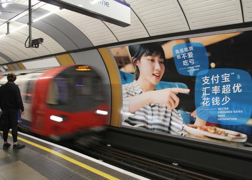 中国侨网英国为吸引中国游客推出多项举措。图为繁忙的伦敦地铁线，醒目刊载中国企业“支付宝”广告。（图片来源：中新社）