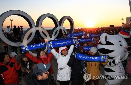 中国侨网资料图片:2018年1月1日,在江陵镜浦海边,平昌冬奥会志愿者们在宣传冬奥。(图片来源:韩联社)