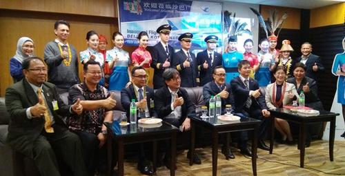 中国侨网马西迪曼俊（前排右四）等在厦门航空公司的北京直飞亚庇首航仪式上，与该机组人员竖起拇指示意。（马来西亚《亚洲时报》）