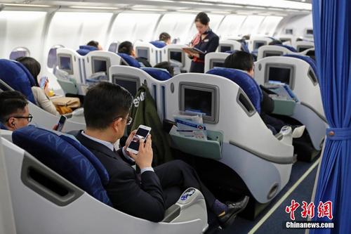 中国侨网资料图：在东航MU5137航班上，旅客全程在飞行模式下可以使用手机。殷立勤 摄