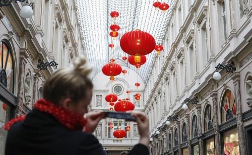 中国侨网资料图片：2月15日，在比利时首都布鲁塞尔，一名游客在圣于贝尔购物长廊拍摄中国红灯笼。新华社记者 叶平凡 摄